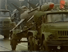a military truck with a missile attached to the back of it