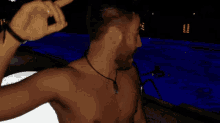 a shirtless man with a beard is pointing at the camera