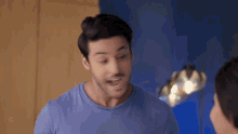 a man in a blue shirt is smiling and looking at the camera