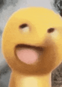 a close up of a yellow smiley face with its tongue sticking out .