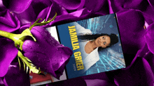 a purple rose is sitting next to a phone that says the jamila grier show