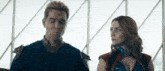 a man and a woman are standing next to each other and looking at each other