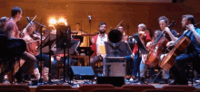 a group of people playing instruments on a stage in front of a box that says ' tf ' on it