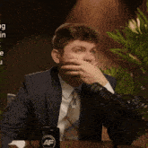 a man in a suit and tie is sitting in front of a microphone with a mug that says anchor af on it