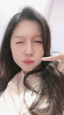 a woman making a funny face with her finger on her face