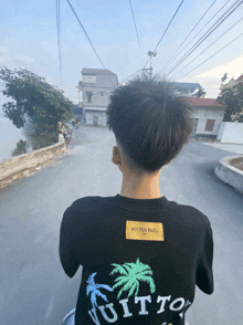 a person wearing a black t-shirt that says vuitton on it
