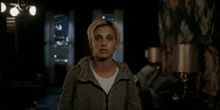 a woman in a dark room with a hoodie on