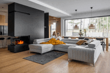 two women sit on a couch in a living room with a fireplace