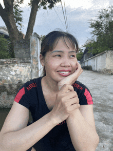 a woman wearing a black shirt that says aeen on the side
