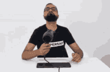 a man with a beard is holding a hair dryer in his hand .