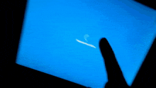 a person 's hand is visible in front of a blue background