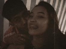 a man and a woman are posing for a picture with the woman sticking out her tongue