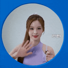 a woman in a purple top is waving her hand in a blue circle with chinese writing on it