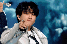 a young man is pointing at the camera with a foreign language on the bottom