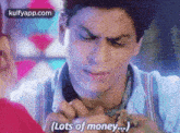 a man is holding a woman 's hand and talking about money .