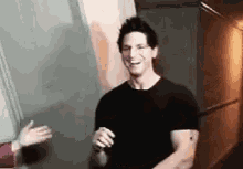 a man in a black shirt is standing next to a woman in a hallway and smiling .