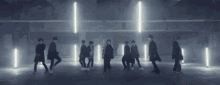 a group of people are standing in a row in a dark room .