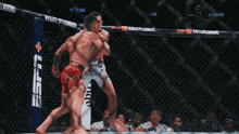 two mma fighters are fighting in a cage with espn on the side