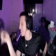 a man wearing headphones is holding a lollipop in his mouth .