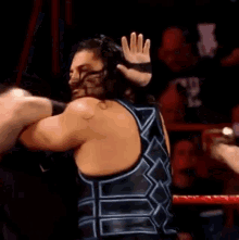 roman reigns is hugging a wrestler in a wrestling ring .
