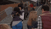 a group of people are standing on a set of stairs with their arms around each other