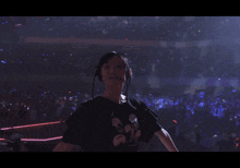 a woman making a peace sign with her hands in front of a crowd