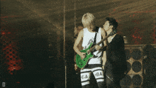 a man holding a guitar and another man holding a microphone with hba written on their pants