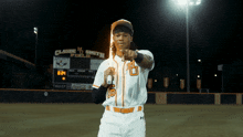 a baseball player in front of a scoreboard that says claude m smith field