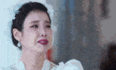 a woman in a wedding dress is crying while wearing a veil