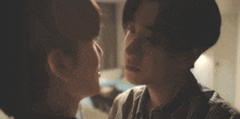 a man and a woman are looking at each other and kissing .