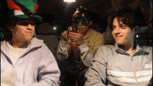 three boys in a car with gifrun.com written on the bottom right