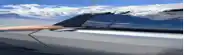 a close up of a car 's side with a blue sky in the background