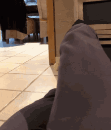 a person laying on the floor with a yellow tennis ball on the floor