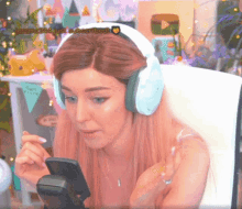 a woman wearing headphones is looking at a cell phone with a watermark that says jasmin266 on it