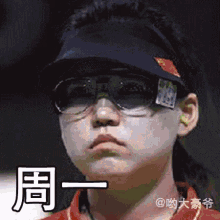 a pixelated image of a person wearing sunglasses and a hat with chinese characters on it