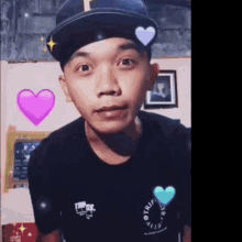 a young man wearing a hat and a black shirt with a heart on his hat is looking at the camera .