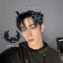 a man with a bow in his hair and the words intak andres on the bottom