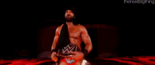 a wrestler is standing on a stage in front of a sign that says jinder mahal .