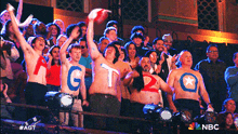 a crowd of people with shirts on that say gtq