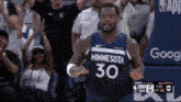 a basketball player wearing a minnesota 30 jersey is standing in front of a crowd of people .