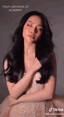 a woman with her eyes closed is wearing a pearl dress