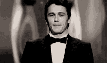 a man in a tuxedo and bow tie is making a funny face .
