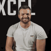a man wearing a white superdry shirt smiles