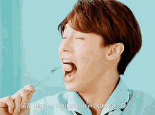 a man in a blue shirt is eating something with a fork in his mouth and the words in a foreign language are below him