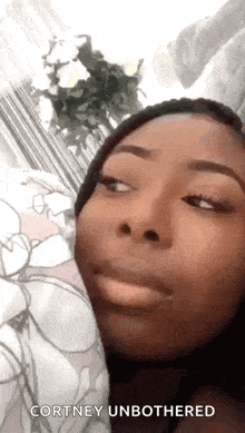 a close up of a woman 's face with the words " courtney unbothered " written below her
