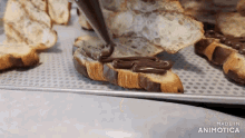 a croissant is being decorated with chocolate and the words made in animotica are on the bottom