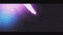 a purple and blue light is coming out of the dark