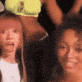 a group of women are standing next to each other and one of them is making a face .