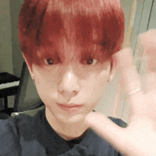 a close up of a person 's face with red hair and a piano in the background .
