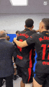 a group of soccer players are hugging each other and one of them has the number 17 on his back